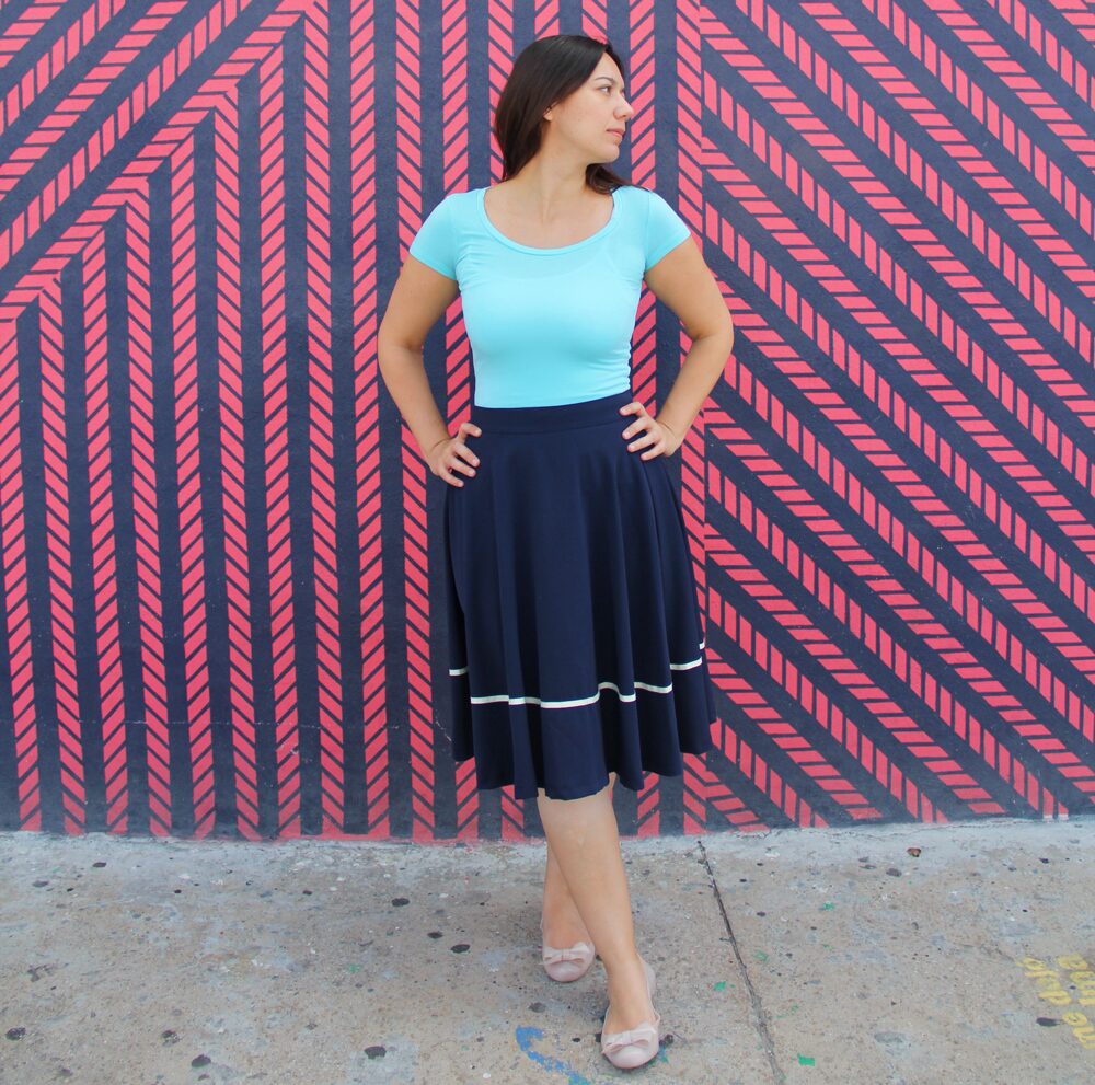 Coco wearing an aqua jersey top with a navy midi skirt.