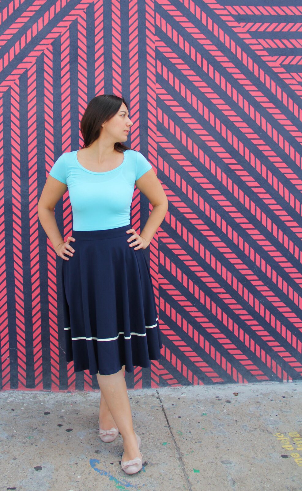 Coco wearing an aqua jersey top with a navy midi skirt.