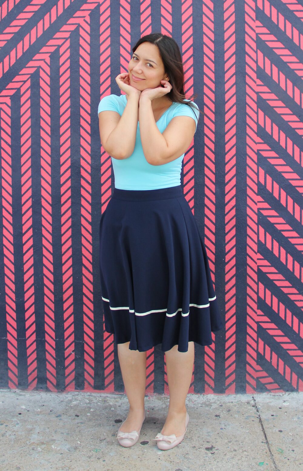 Coco wearing an aqua jersey top with a navy midi skirt.