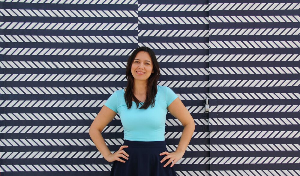 Coco wearing an aqua jersey top with a navy midi skirt.