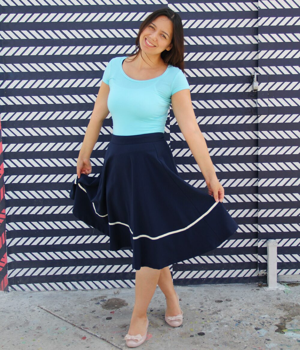 Coco wearing an aqua jersey top with a navy midi skirt.
